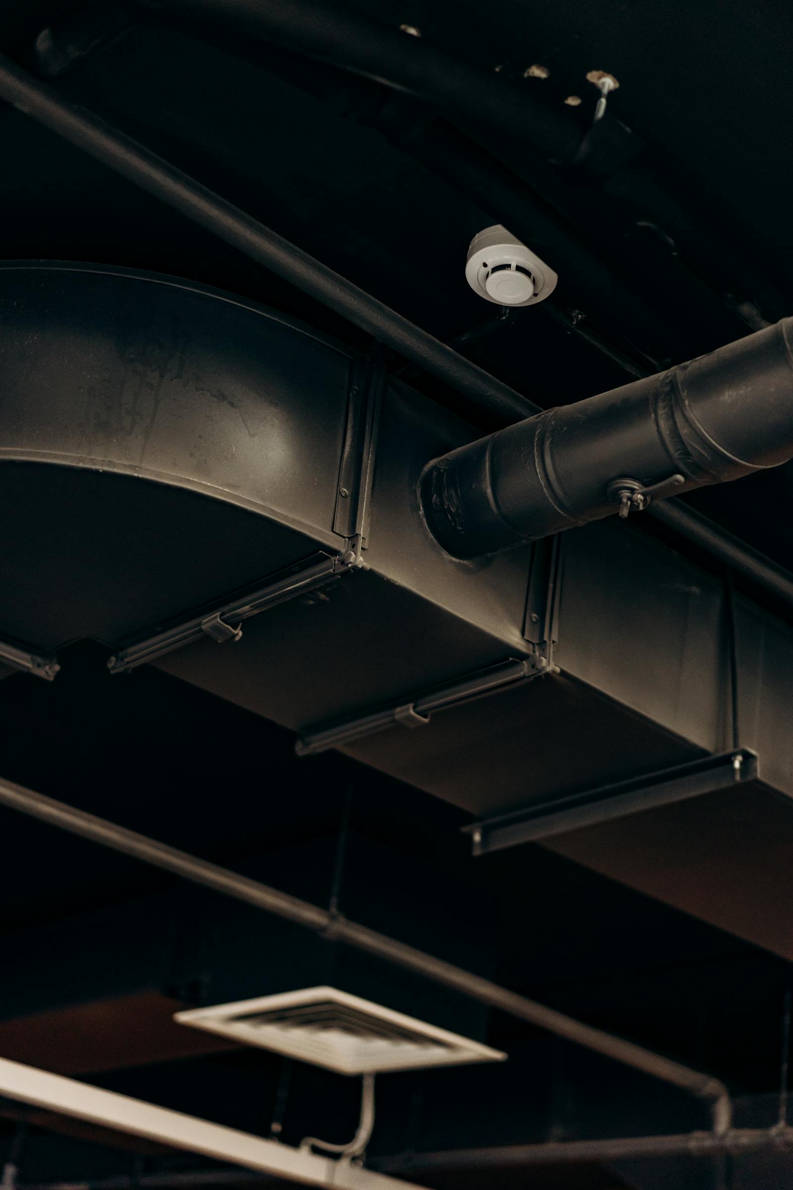 Commercial kitchen exhaust ductwork running through a ceiling void