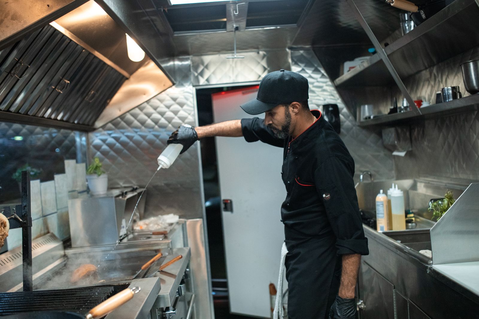 Stainless steel commercial kitchen exhaust hood over a cook station